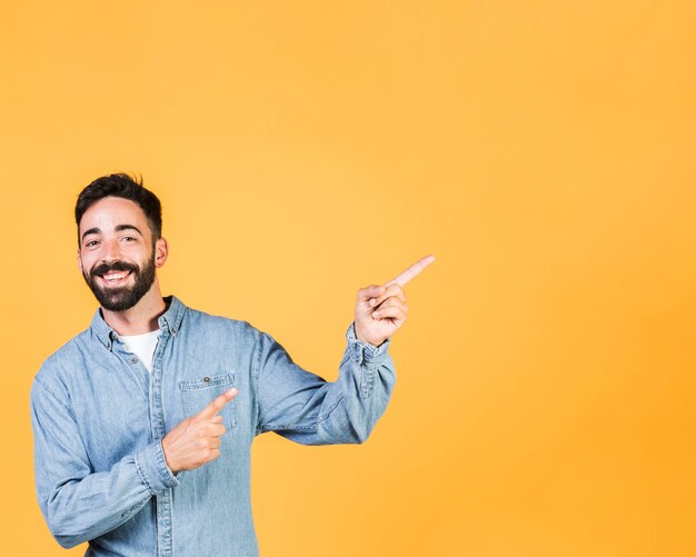 Chico de tiro medio sonriente apuntando hacia arriba