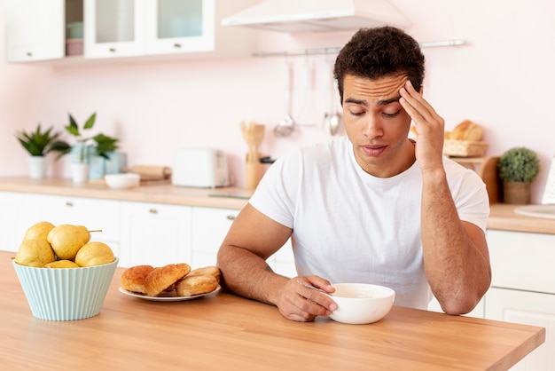 Foto gratuita chico de tiro medio con tazón de cereales en la cocina