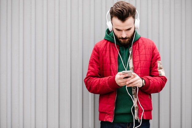 Chico de tiro medio con teléfono inteligente y auriculares