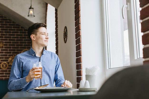 Foto gratuita chico tomando una cerveza en un restaurante