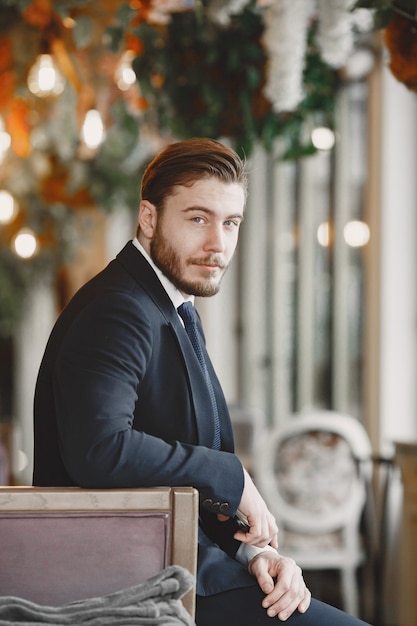 Chico de traje negro. Hombre en el restaurante.