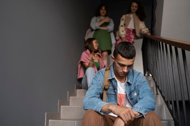 Chico triste siendo intimidado en ángulo bajo de escaleras