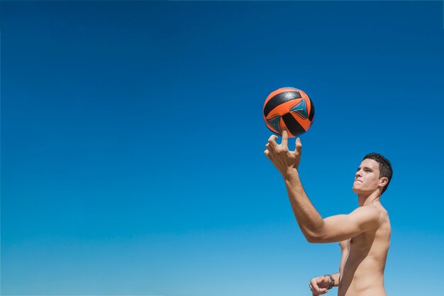 Chico con voleibol en dedo