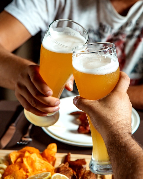 Chicos bebiendo cerveza con aperitivos mixtos