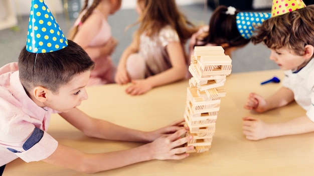 Chicos enfocados en juegos de madera