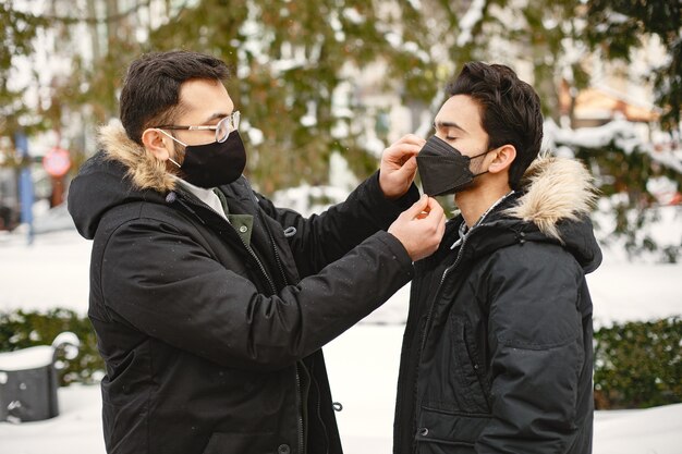 Chicos indios con máscaras. Hombres en la calle en invierno. Los niños usan máscaras.