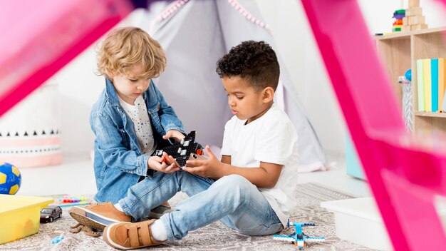 Chicos jóvenes en carpa en casa jugando con juguetes