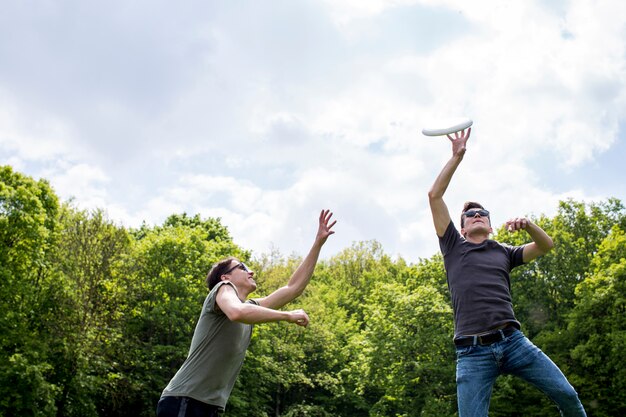 Chicos jóvenes jugando frisbee en la naturaleza