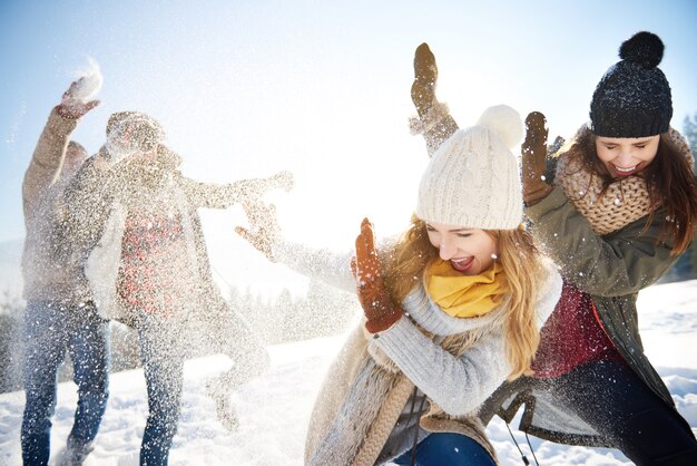 Chicos lanzando bolas de nieve a las chicas