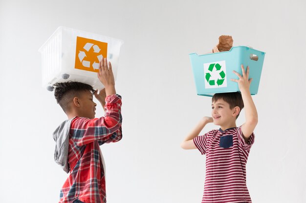 Chicos lindos con cajas de reciclaje