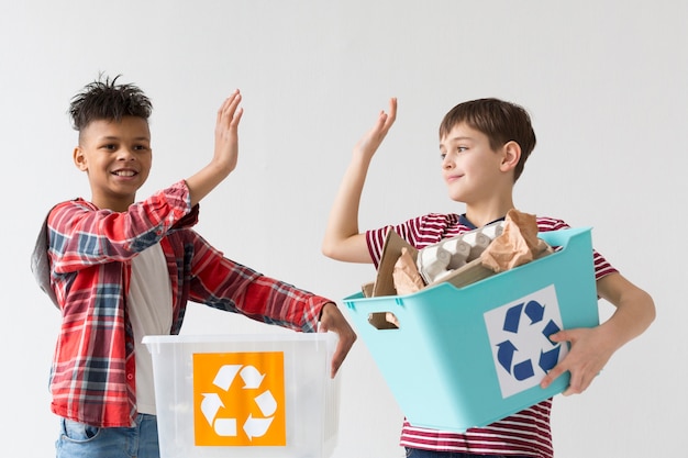 Chicos lindos felices de reciclar juntos