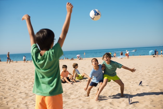 Foto gratuita chicos peleando por la pelota cuando juegan al fútbol.