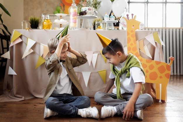 Foto gratuita chicos de tiro completo con sombreros de fiesta.