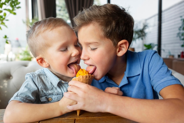 Chicos de tiro medio comiendo helado