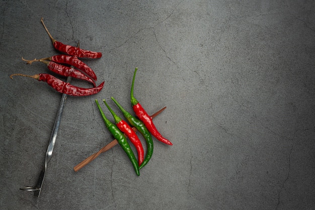 El chile rojo tiene una brocheta sobre negro.