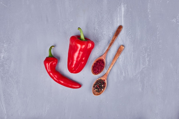 Foto gratuita chiles rojos picantes con pimentón y pimiento en cucharas de madera.