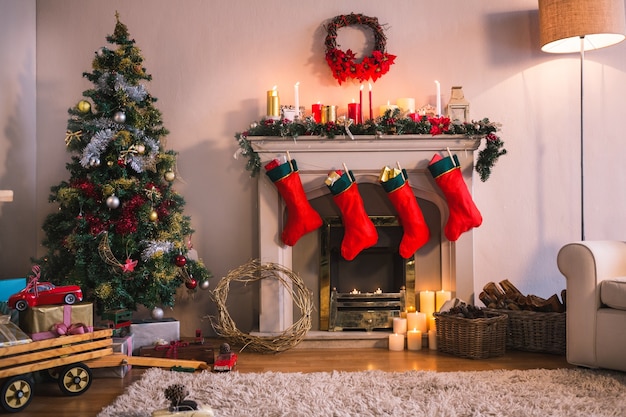 Chimenea con calcetines rojos colgando y un árbol de navidad