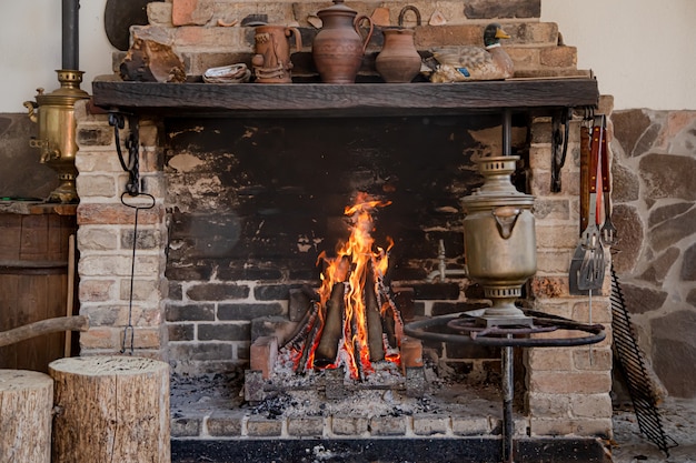 Chimenea grande con fuego ardiente y elementos decorativos.