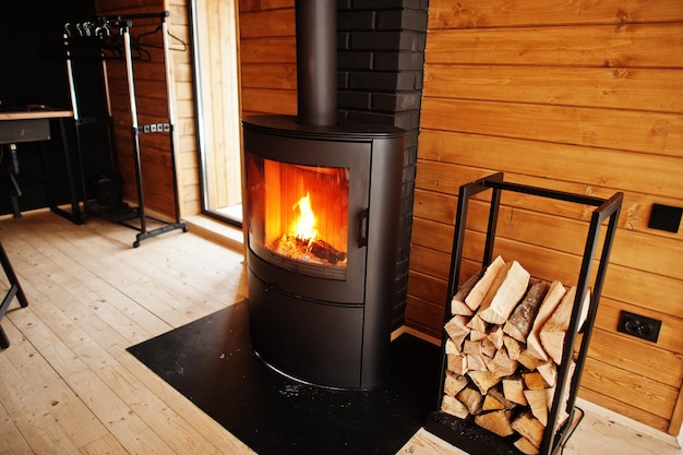 Chimenea con maderas en casa de madera moderna