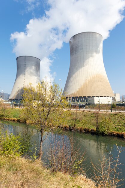 Chimeneas de fábrica nuclear y río en verano