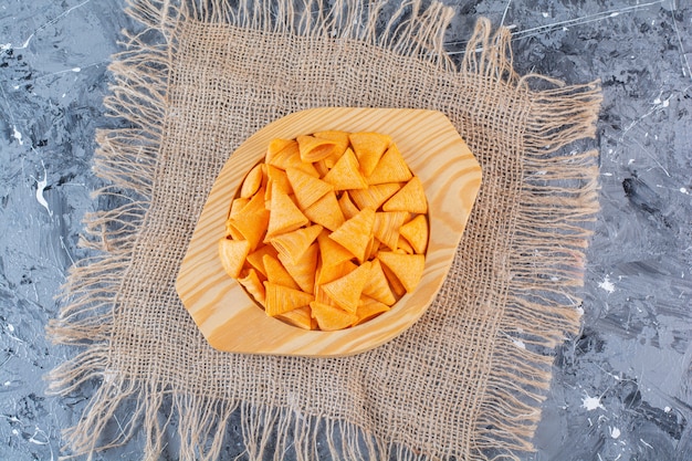 Chips de cono de patata en placa de madera en textura, en la superficie de mármol