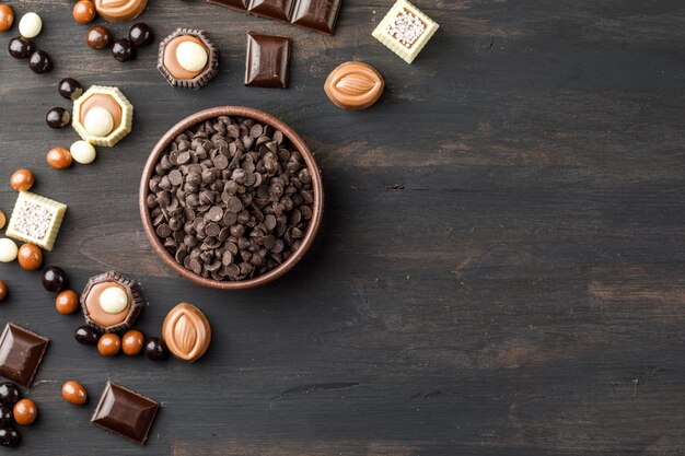 Choco cae con bolas de choco, barras de chocolate y caramelo en un recipiente de arcilla