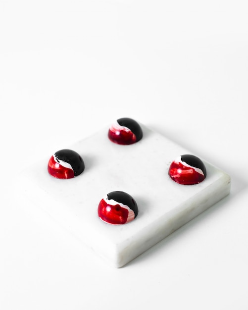 Choco caramelos diseñados chocolates de arte coloreados en la superficie blanca