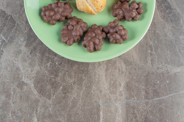 Chocolate con avellanas y galleta en un plato sobre azul.