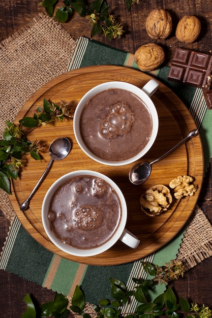 Chocolate caliente y cucharas en tablero de madera