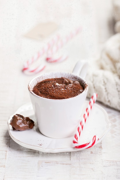 Chocolate caliente de Navidad con cacao y bastón de caramelo, primer plano con nieve sobre un fondo