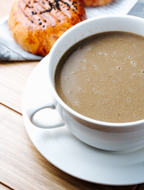 Chocolate caliente servido con bollos recién horneados