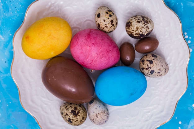 Foto gratuita chocolate y coloridos huevos de pascua en placa