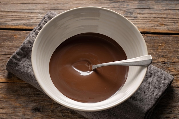 Chocolate derretido en taza sobre fondo gris. De cerca