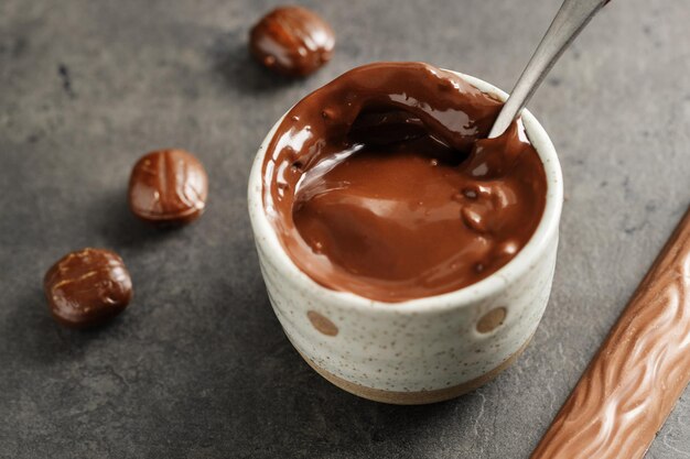 Chocolate derretido en taza sobre fondo gris. De cerca