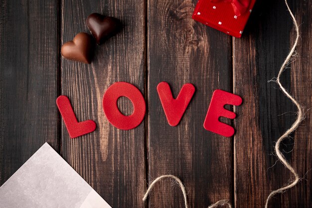 Chocolates en forma de corazón sobre fondo de madera con amor