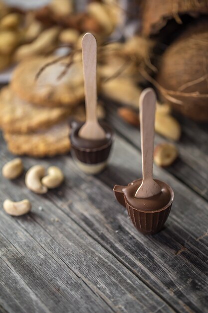 Chocolates, nueces y cocos sobre superficie de madera