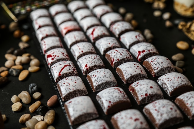 Chocolates con revestimiento blanco y rojo en la vista lateral de pizarra de seastones