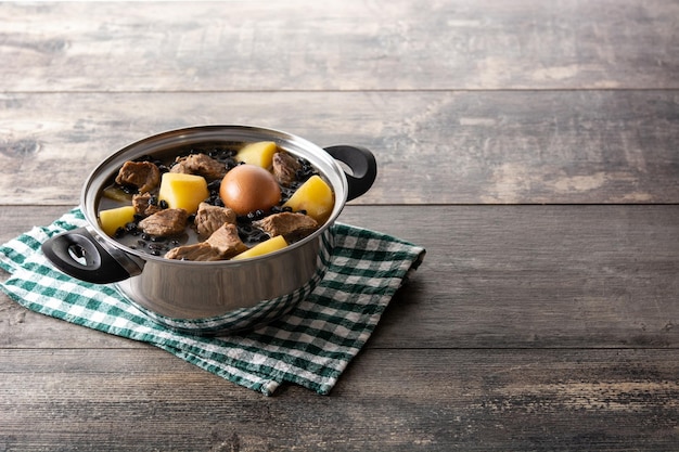 Foto gratuita cholent judío tradicional en cazuela sobre mesa de madera