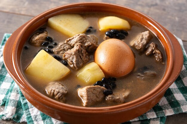 Cholent judío tradicional sobre mesa de madera