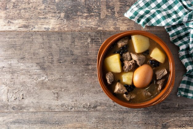 Cholent judío tradicional sobre mesa de madera