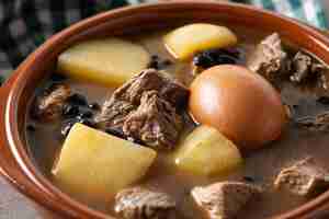 Foto gratuita cholent judío tradicional en tazón sobre mesa de madera