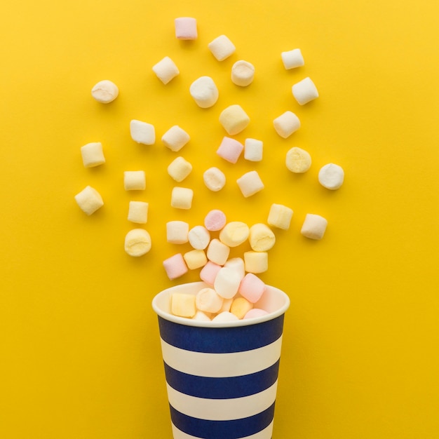 Foto gratuita chuches cayéndose de vaso de cartón de cerca