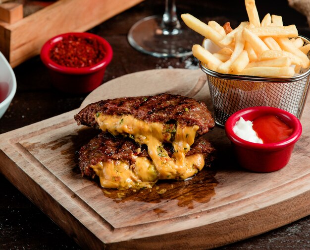 Chuleta de carne con queso dentro y papas fritas