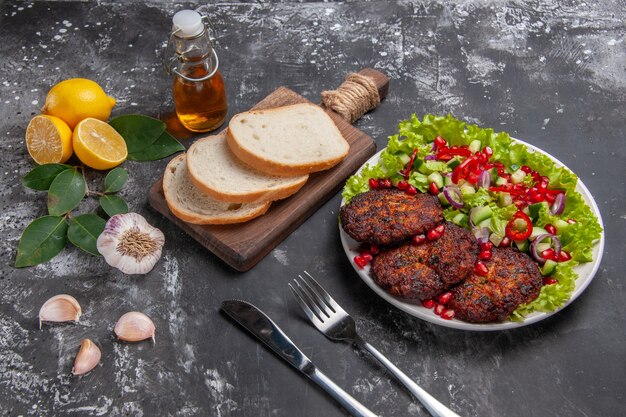 Chuletas de carne de media vista superior con ensalada y pan