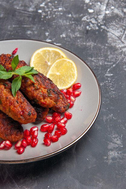 Chuletas de carne de vista frontal formadas largas con rodajas de limón