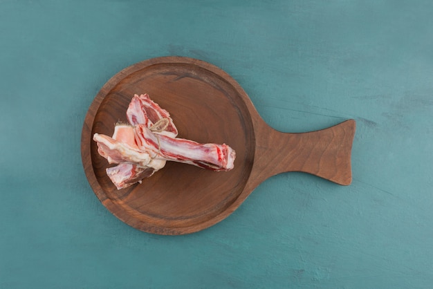 Foto gratuita chuletas de cordero crudo sobre tabla de madera.