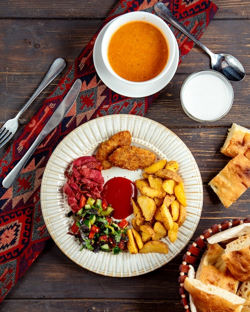 Foto gratuita chuletas fritas y papa con hierbas y sopa