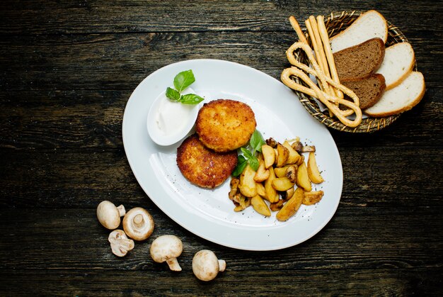 Chuletas de pollo con papas fritas y champiñones