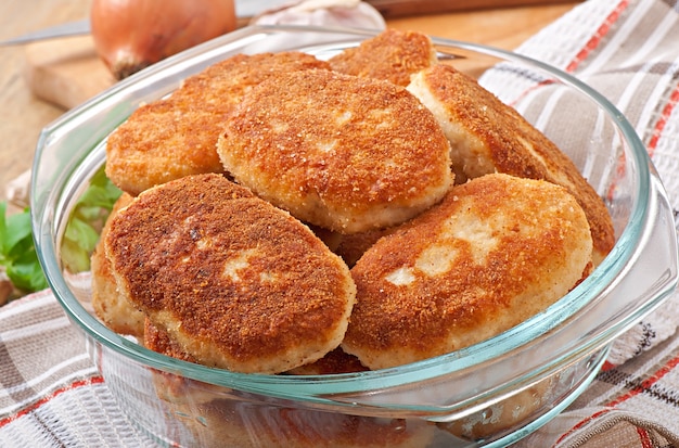 Chuletas de pollo en un recipiente de vidrio.