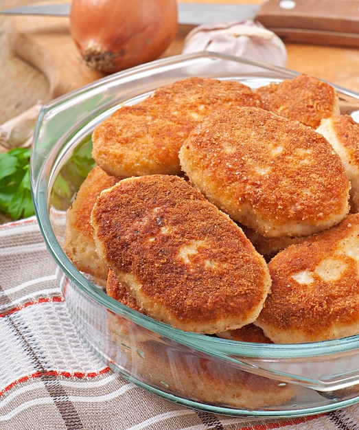 Chuletas de pollo en un recipiente de vidrio.